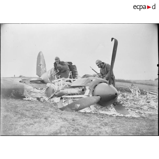 Deux soldats de la 4e armée regardent un moteur d'avion bombardier allemand abattu.