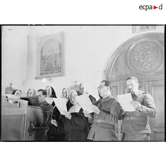Photographie de groupe de soldats de la 4e armée et de religieuses qui chantent dans une chorale.