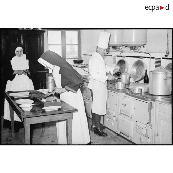 Soldats de la 4e armée et religieuses qui travaillent dans les cuisines d'un établissement religieux.