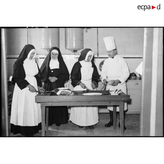 Soldats de la 4e armée et religieuses qui travaillent dans les cuisines d'un établissement religieux.