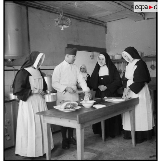 Soldats de la 4e armée et religieuses qui travaillent dans les cuisines d'un établissement religieux.