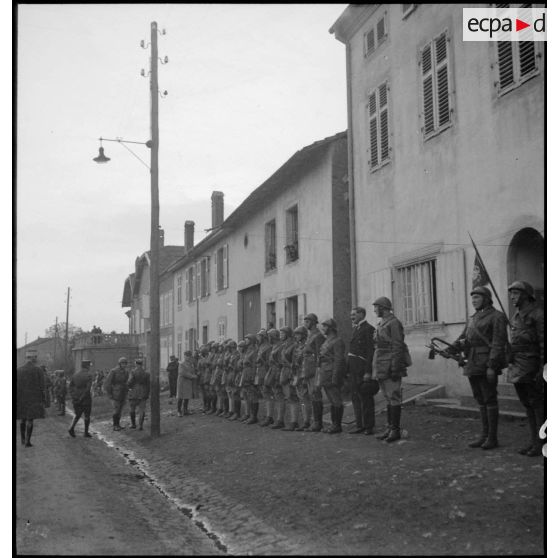 Plan général de la cérémonie militaire dans une rue d'un village du secteur de la 4e armée.