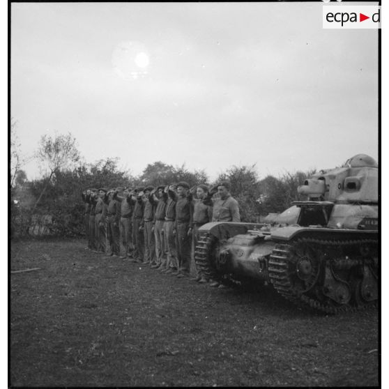Des soldats de la 4e armée saluent près d'un char Renault R35.