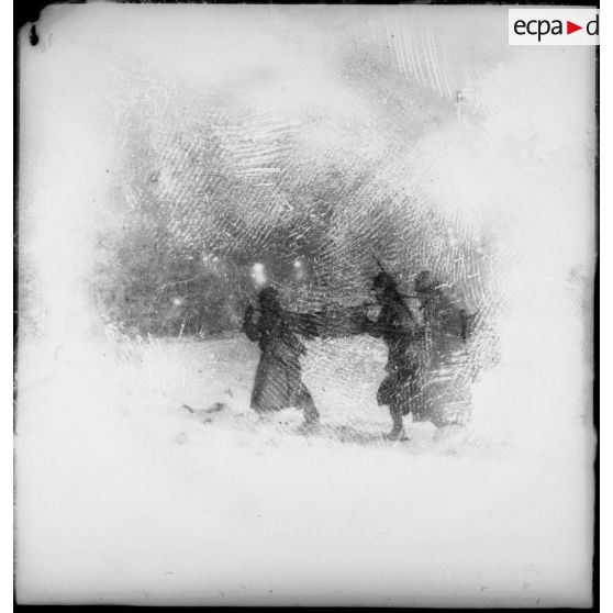 Des soldats de la 4e armée portent un panier de pains dans la neige lors d'une corvée.