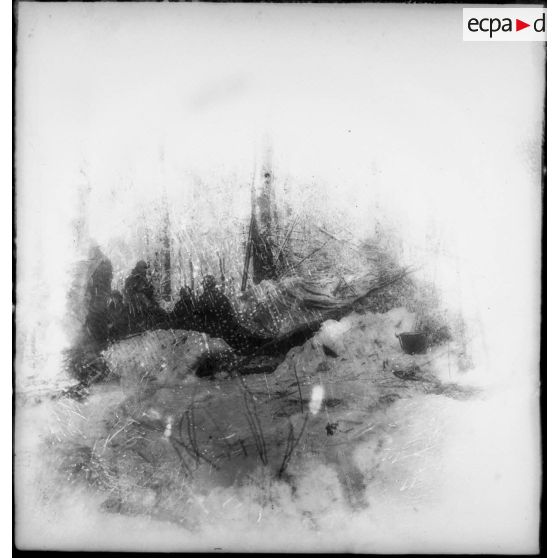 En forêt, des soldats de la 4e armée se tiennent près de toiles de tentes recouvertes de neige.