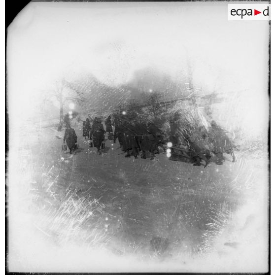 Des soldats de la 4e armée poussent des chariots de ravitaillement dans la neige lors d'une corvée.