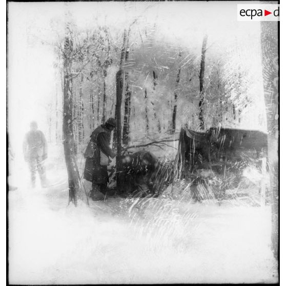 En forêt, des soldats de la 4e armée se tiennent près de toiles de tentes recouvertes de neige.