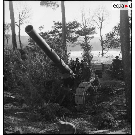 Une pièce de 155 mm GPF de la 5e armée de trois quarts avant, mise en batterie à la lisère d'un bois en Alsace.