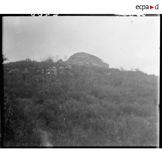 Des soldats de la 5e armée progressent sur un sentier en pente.