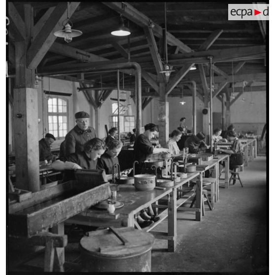 Plan général d'un atelier où des femmes travaillent à la fabrication de piles électriques.