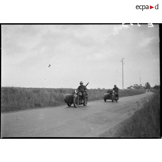 Des motos Terrot RDA et side DTP de la 5e armée se déplacent en colonne sur une route.