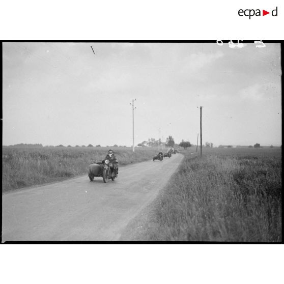 Des motos Terrot RDA et side DTP de la 5e armée se déplacent en colonne sur une route.