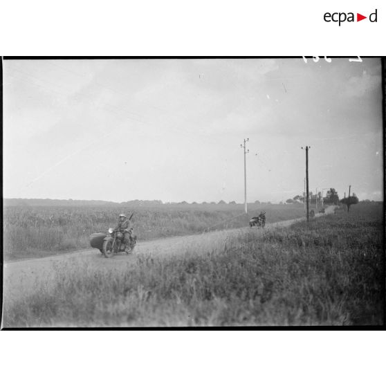 Des motos Terrot RDA et side DTP de la 5e armée se déplacent en colonne sur une route.