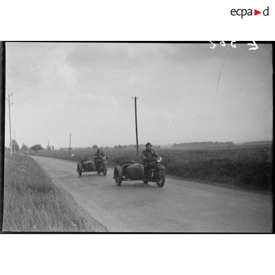 Des motos Terrot RDA et side DTP de la 5e armée se déplacent en colonne sur une route.