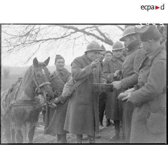 Après le travail aux champs un capitaine, entouré de soldats de la 5e armée, mange.