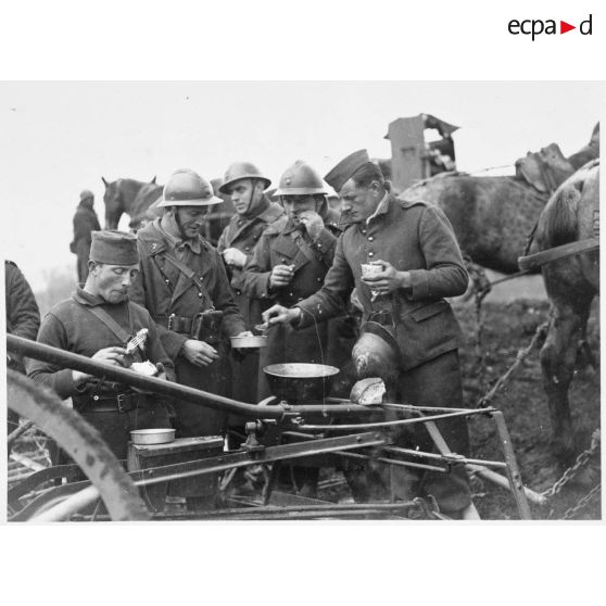Après le travail aux champs des soldats de la 5e armée mangent près d'une machine agricole.