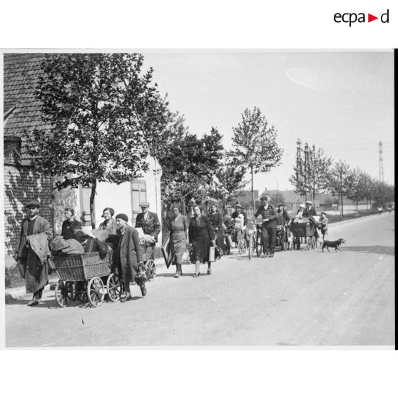 Un groupe de réfugiés marchent sur une route du Bas-Rhin dans le secteur de la 5e armée.