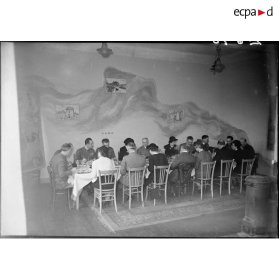 Le général d'armée Réquin, lors d'un repas, est entouré de diverses personnalités civiles et militaires.