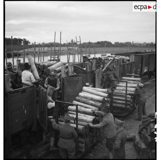 A Strasbourg, sur les quais du port fluvial  des dockers chargent du bois dans des wagons.