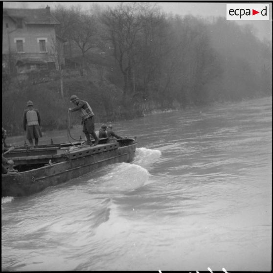 Des sapeurs du génie de la 6e armée manoeuvrent une barge pour la construction d'un pont flottant.