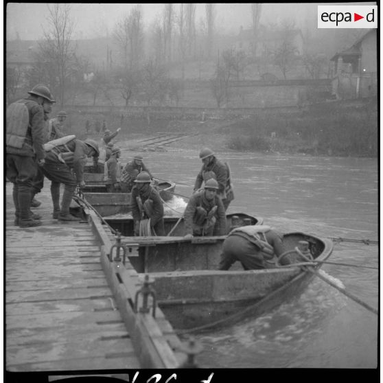 Des sapeurs du génie de la 6e armée manoeuvrent des barges pour la construction d'un pont flottant.
