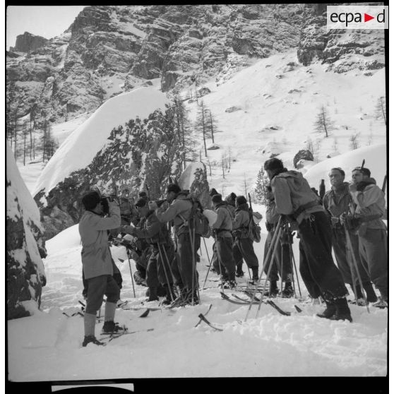 Un opérateur du SCA filme des éclaireurs-skieurs de la 6e armée lors d'une pause en montagne.