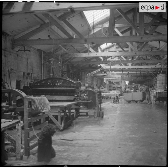 Des ouvrières et des soldats travaillent à la fabrication de chaussures pour l'armée dans une usine.