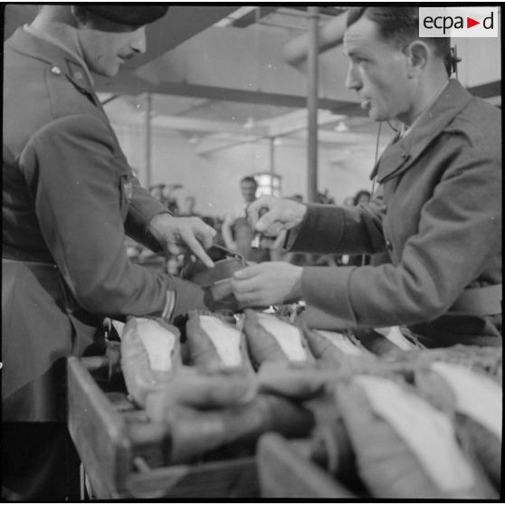 Des ouvrières et des soldats travaillent à la fabrication de chaussures pour l'armée dans une usine.