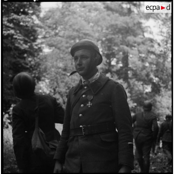 Officier subalterne d'une troupe motorisée de la 7e armée, décoré de la croix de guerre dans une forêt.