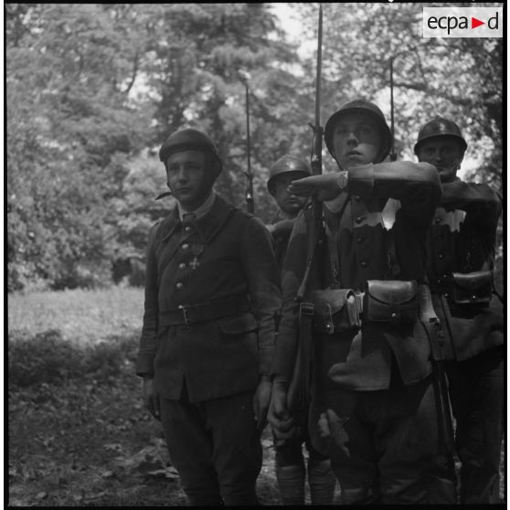 Un soldat d'une unité motorisée de la 7e armée, décoré de la croix de guerre dans une forêt.