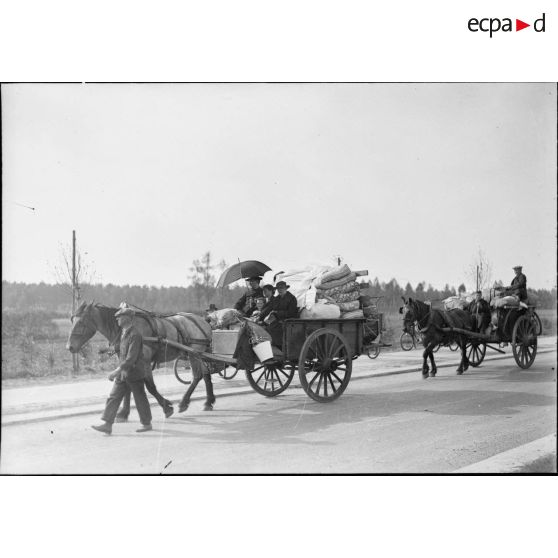 Ces familles fuient la Belgique à bord de charettes tractées par des chevaux.