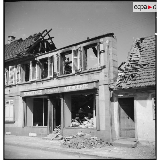Un magasin de bonneterie et de mercerie de l'enseigne Schuster en ruine.