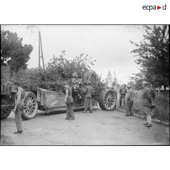 Des soldats de la 7e armée s'affairent autour d'un canon long Schneider de calibre 220 mm (modèle 1917) sur une route de campagne.