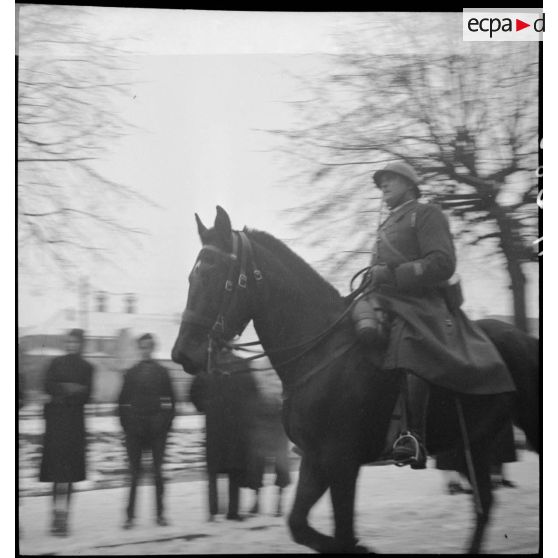 Officier supérieur à cheval défilant à l'occasion d'une prise d'armes dans une commune du secteur de la 8e armée.