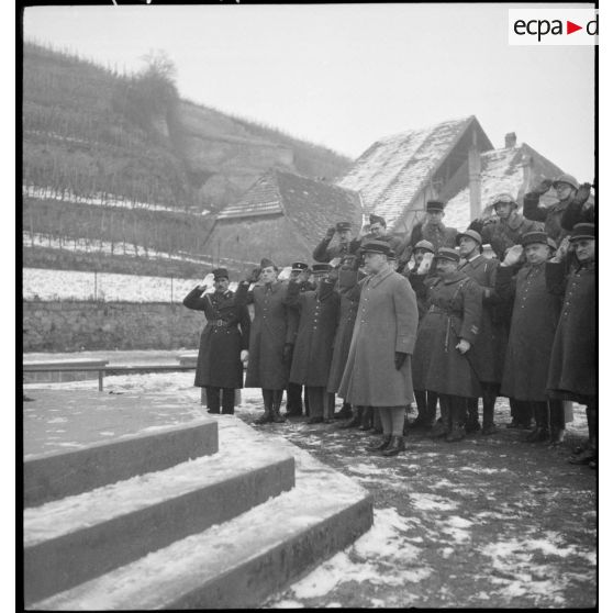 Salut d'un groupe d'officiers devant un monument aux morts d'une commune du secteur de la 8e armée.