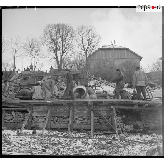 Soldats participant à la construction de fortification dans un endroit enneigé.