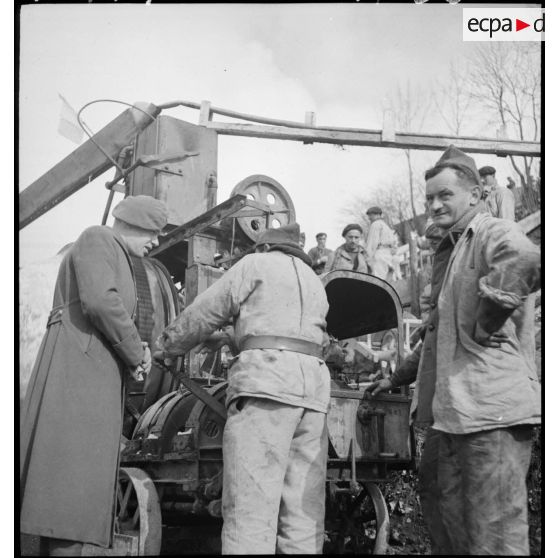Trois soldats autour d'une machine permettant la construction de fortifications.