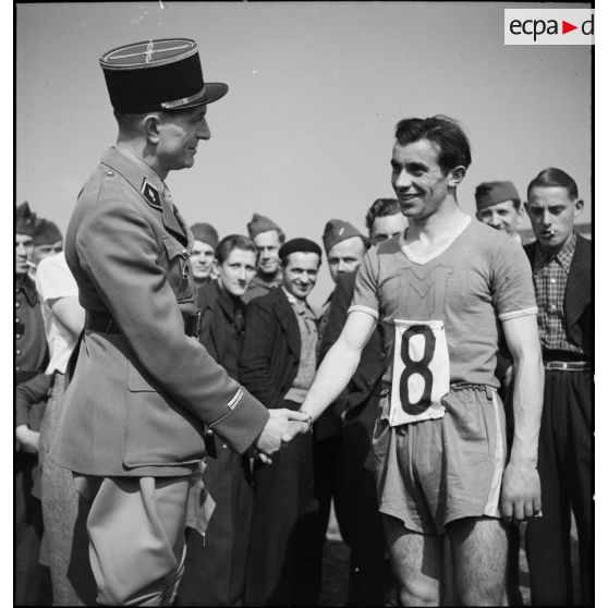 Un lieutenant félicite le vainqueur d'une course d'athlétisme.