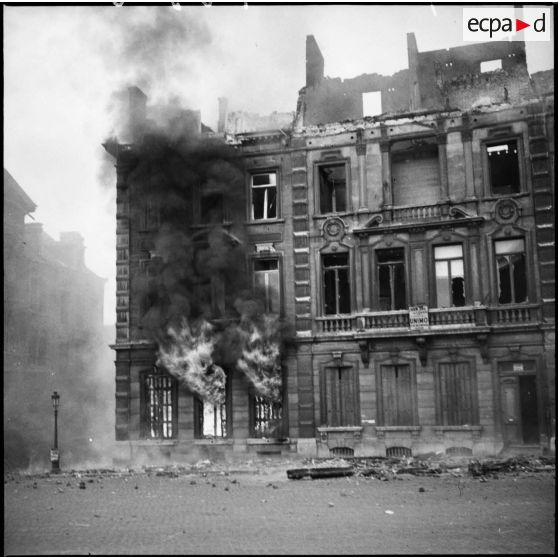 Bâtiments de la place Leopold de Namur en ruines et en feu après les bombardements allemands du 12 mai 1940.