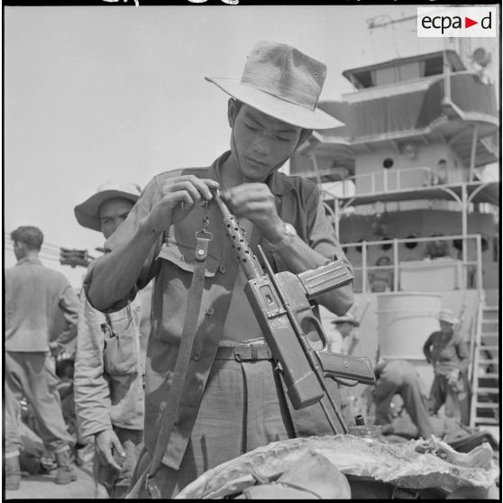 36 Un chasseur du 3e BCC nettoie un PM (Pistolet-Mitrailleur) MAT 49 sur le LST (Landing Ship Tank) "Golo". [description provisoire]