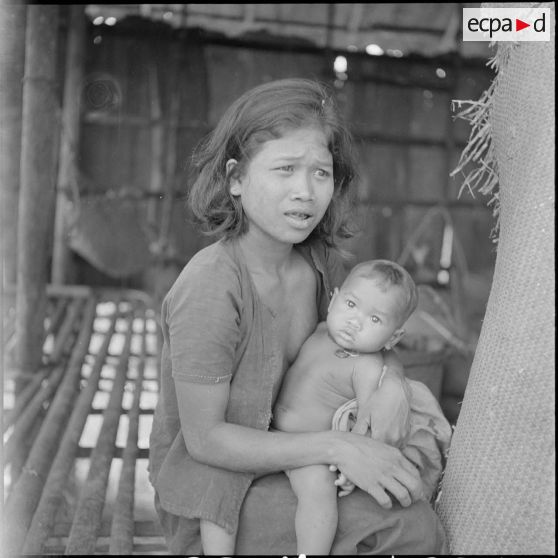 52 Femme cambodgienne portant son bébé, sur le seuil de sa case. [description provisoire]
