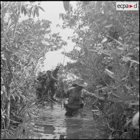 53 Le sergent-chef Robert Queyrad, chef de section,  progresse difficilement en terrain marécageux. [description provisoire]