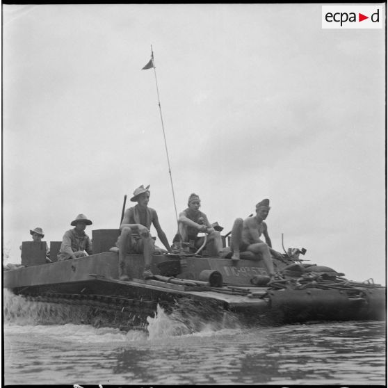 70 Plan moyen d'un LVT-4 (Landing Vehicle Tank - "Alligator") avec des hommes à bord, avançant dans l'eau d'une rivière. [description provisoire]