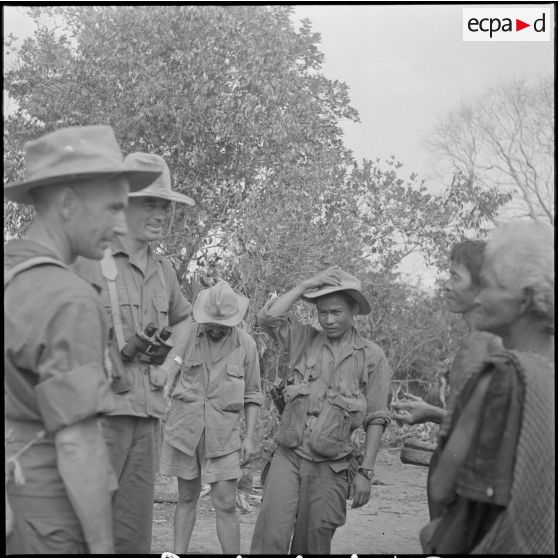 89 A l'arrivée dans un village, le commandant Thomas, entouré d'hommes du 3e BCC,  interroge des habitants. [description provisoire]