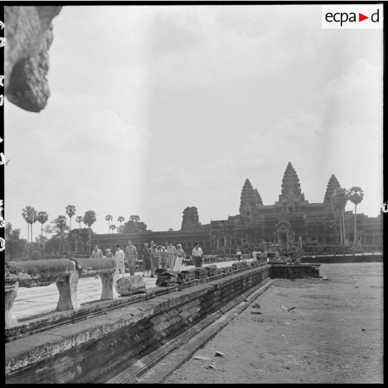 Le général Clark et son épouse accompagnés d'un délégation avancent sur une grande allée d'Angkor Vat.
