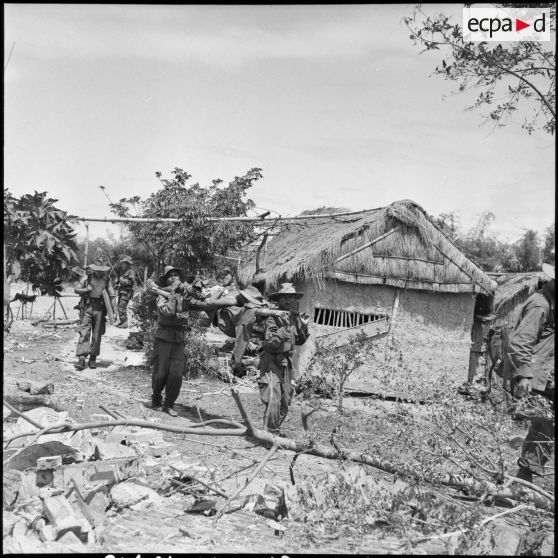 Des militaires de retour d'une reconnaissance au cours de l'opération Atlante portent un blessé sur une civière.