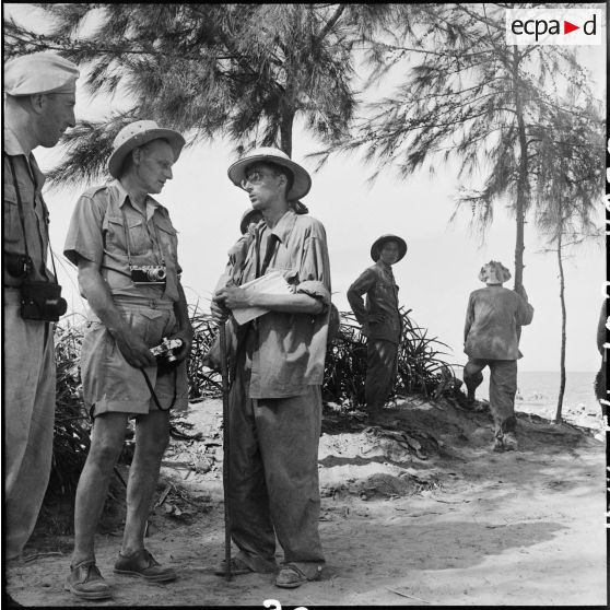 Deux journalistes étrangers écoutent le récit d'un prisonnier de guerre de l'Union française libéré par le vietminh à Sam Son.