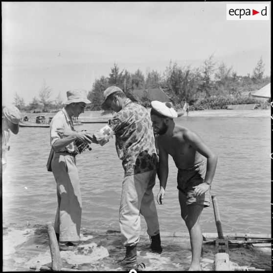 Arrivée de reporters de la presse française sur un radeau de bambous au cours d'un échange de prisonniers à Sam Son.