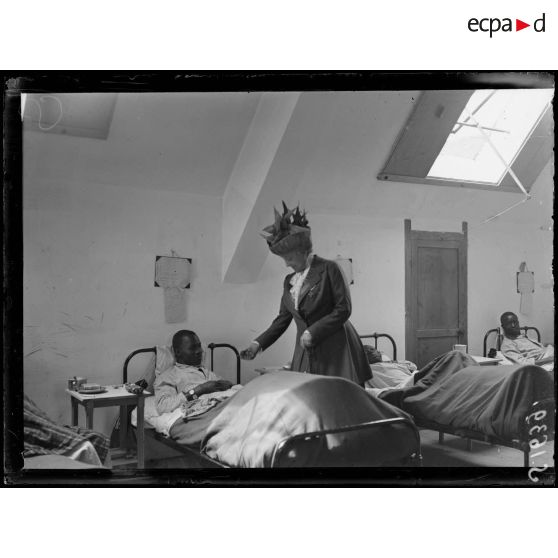 Asnières-sur-Oise. Ancienne abbaye de Royaumont. Hôpital écossais de 400 lits. Madame d'Haussonville offrant un jouet à un nègre malade. [légende d'origine]