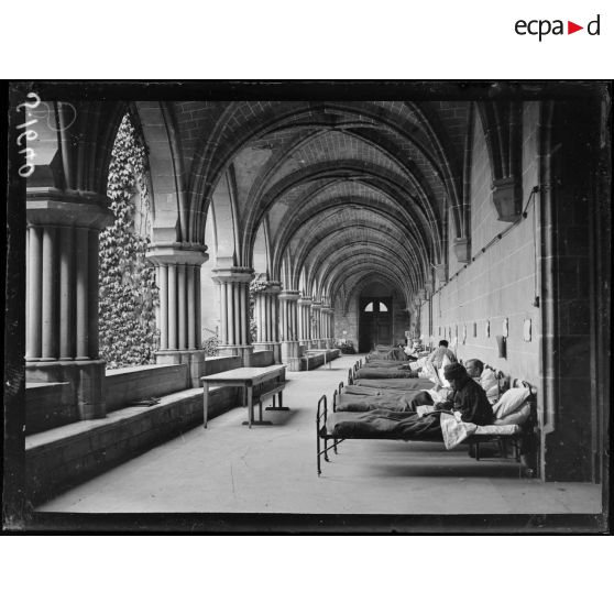 Asnières-sur-Oise. Ancienne abbaye de Royaumont. Hôpital écossais de 400 lits. Malades dans leur lit dans une galerie du cloître de l'abbaye. [légende d'origine]